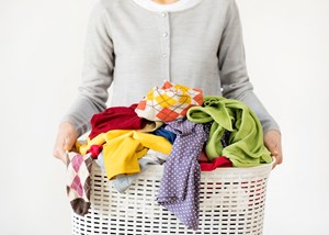 holding basket of dirty clothes