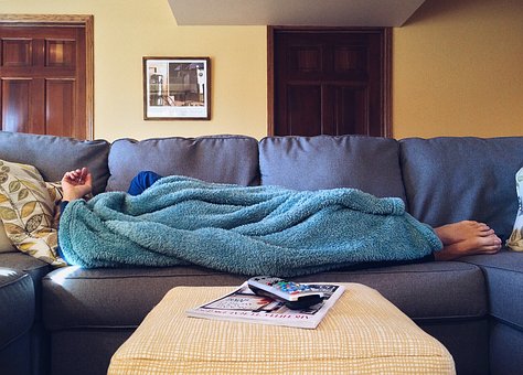 person under blanket on sofa