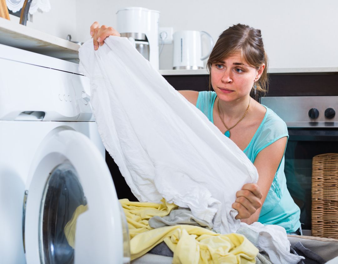 Woman looking tired doing laundry
