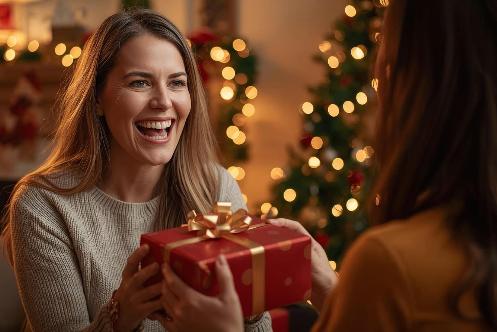 Woman happily receiving a holiday gift, illustrating thoughtful wardrobe-care gift ideas.